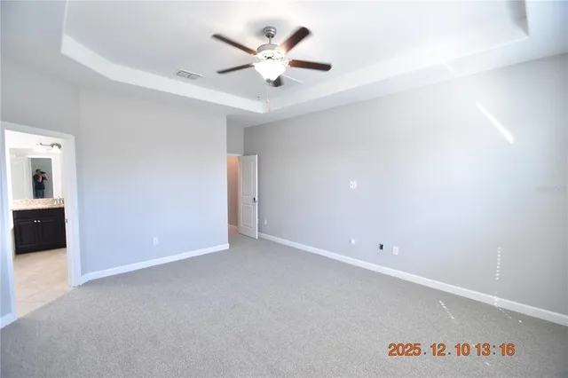 an empty room with a chandelier fan and a table