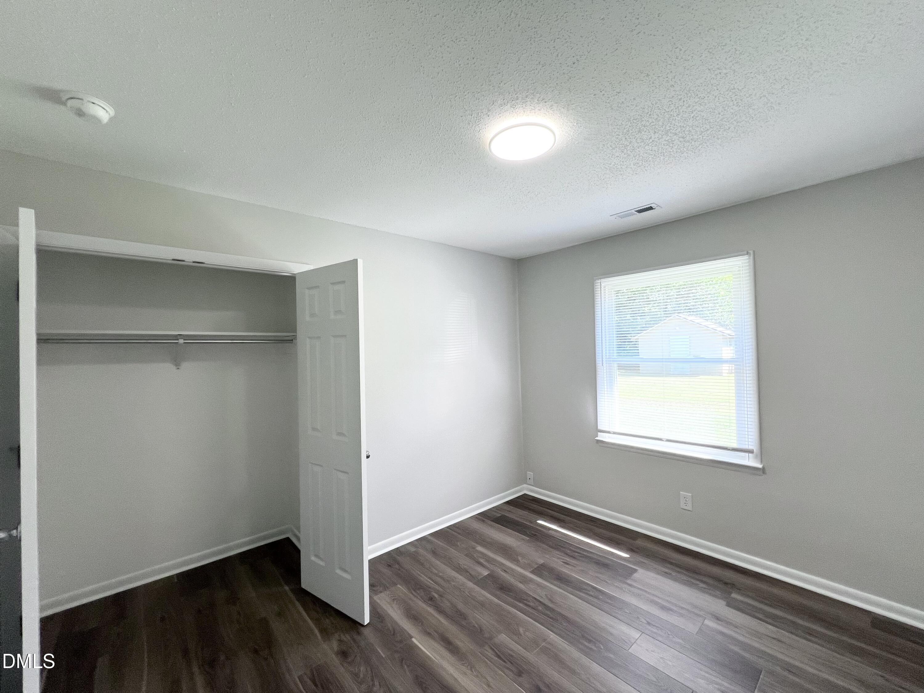 200 Infinity Road Durham, NC 27712 - Photo 15 of 32 a view of an empty room with wooden floor and a window