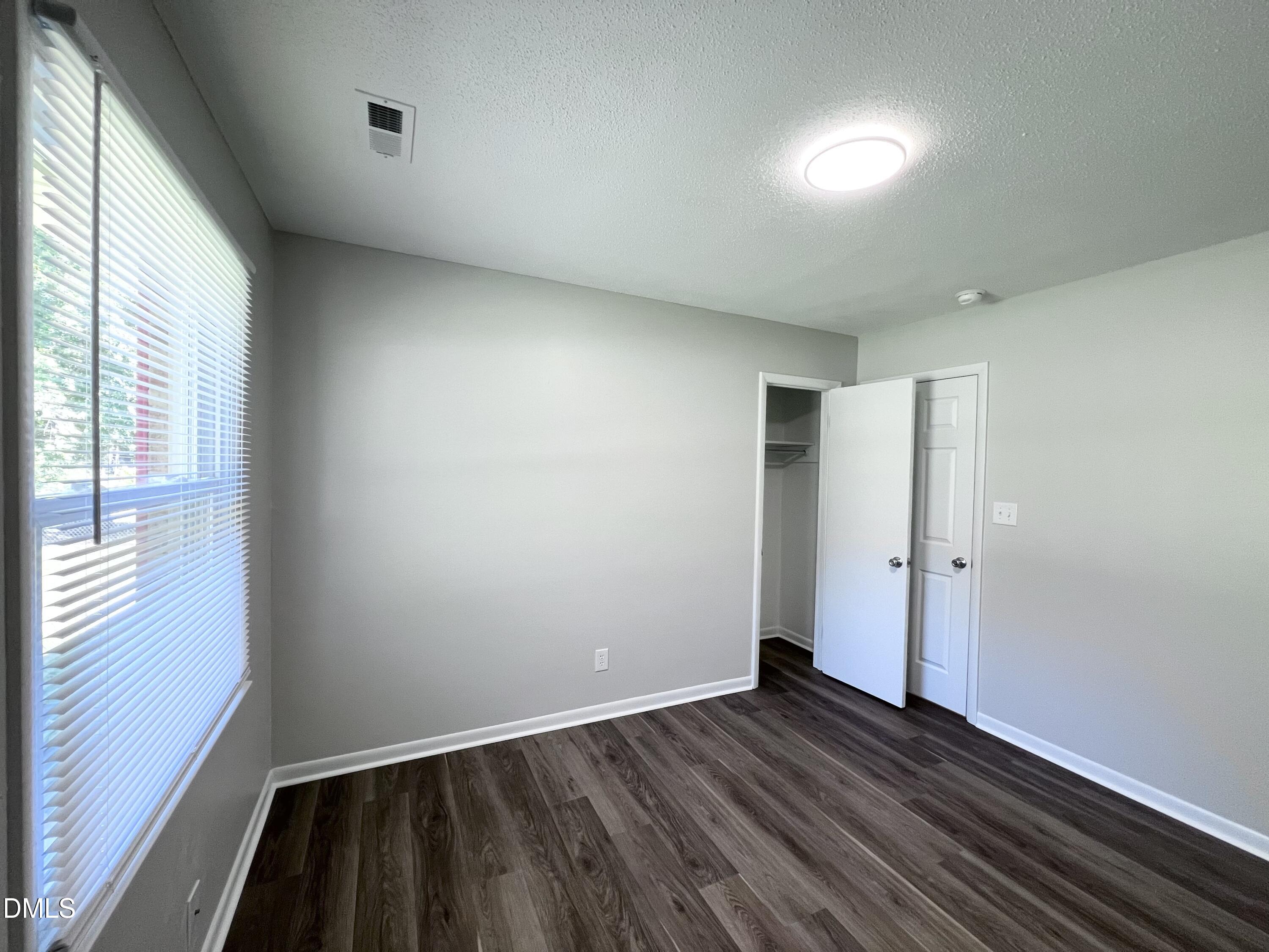 200 Infinity Road Durham, NC 27712 - Photo 18 of 32 a view of an empty room with wooden floor and a window