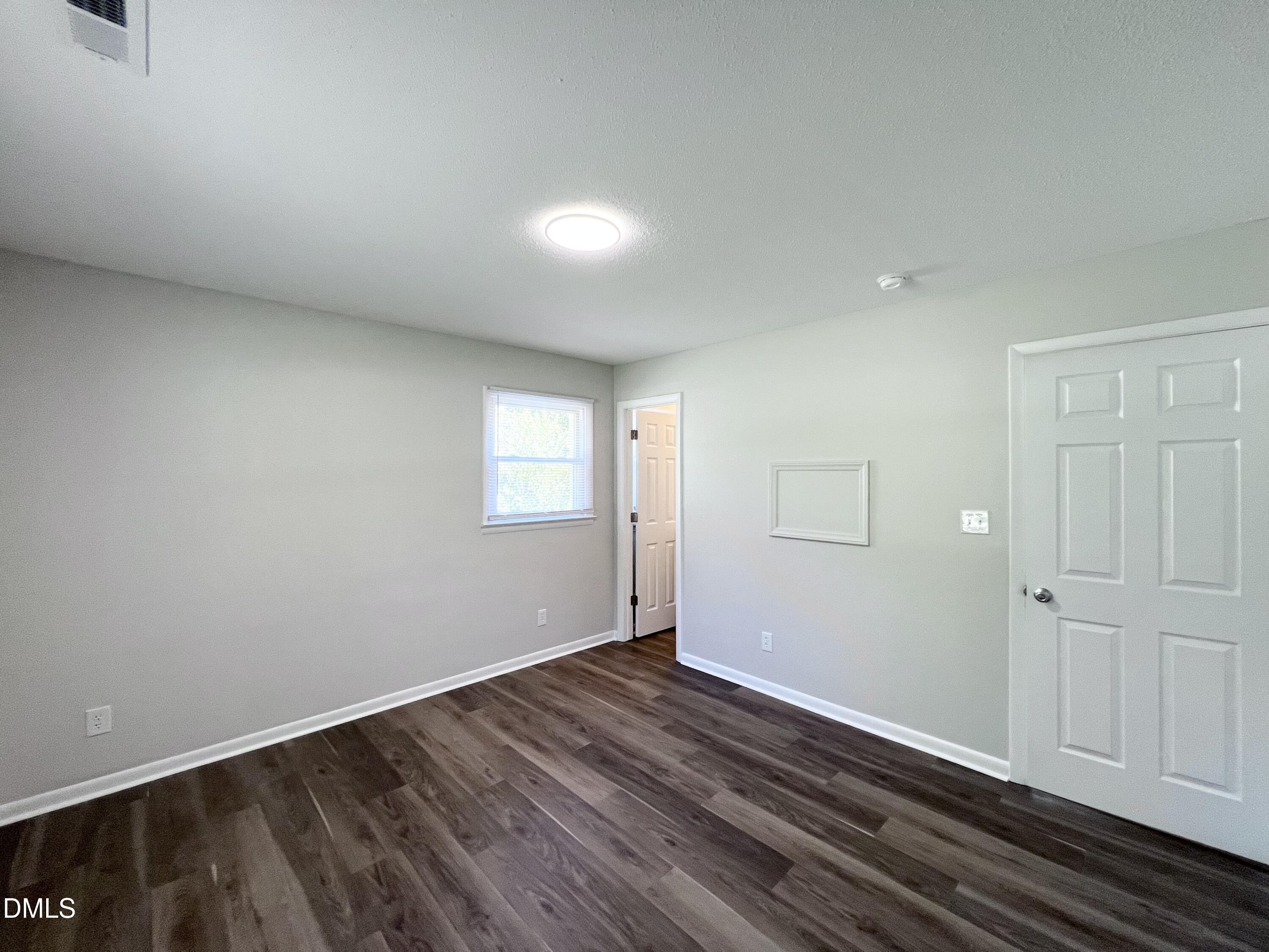 200 Infinity Road Durham, NC 27712 - Photo 27 of 32 a view of an empty room with wooden floor and a window