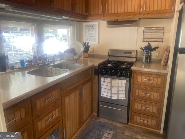 a kitchen with granite countertop a sink and a stove