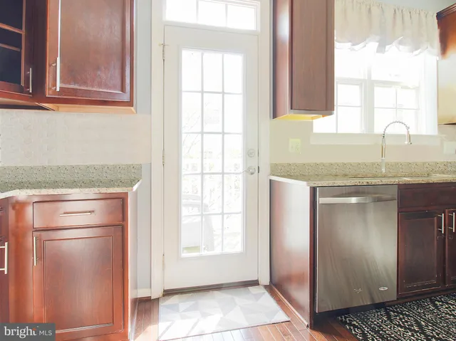 a kitchen with granite countertop white cabinets and a window