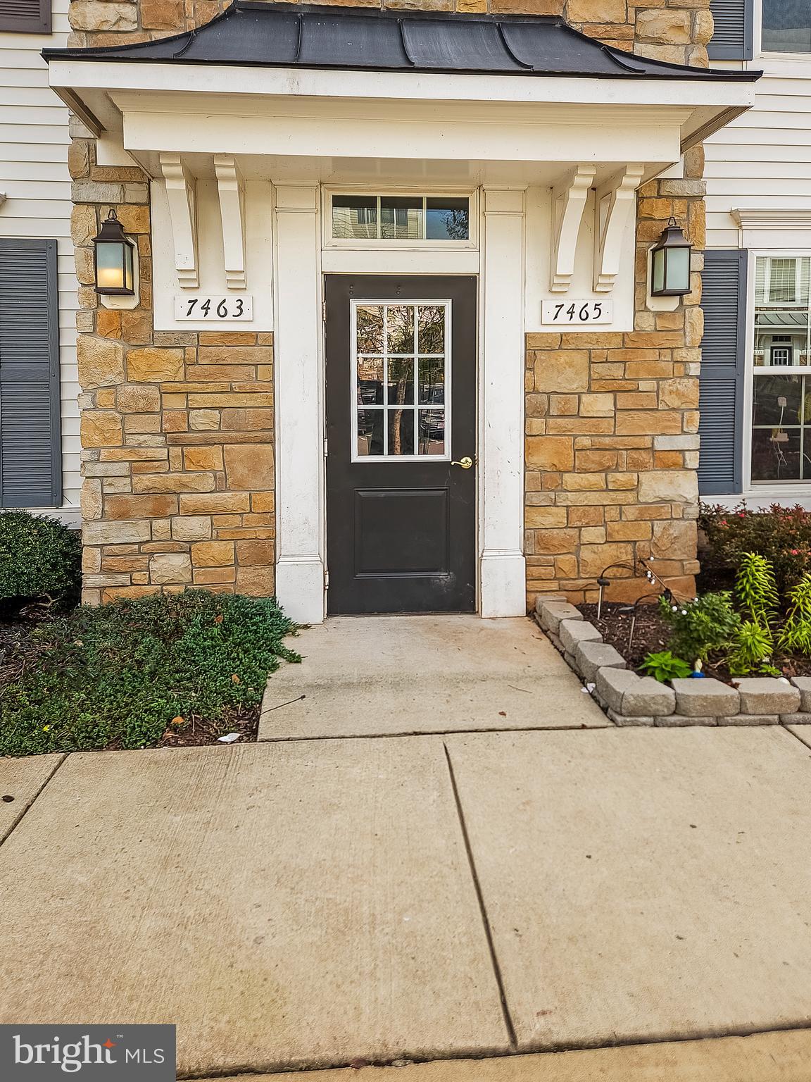 7465 Riding Meadow Way, Unit 42 Manassas, VA 20111 - Photo 3 of 26 a front view of a house with a garden