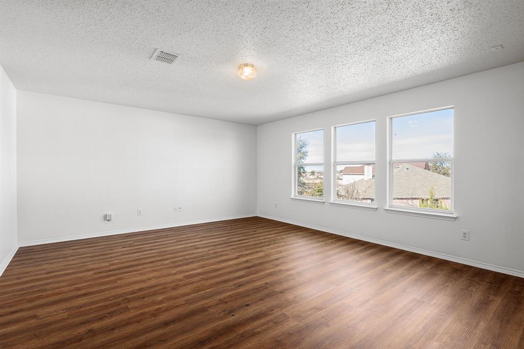 4816 Star Ridge Drive Fort Worth, TX 76133 - Photo 12 of 23 an empty room with wooden floor and windows