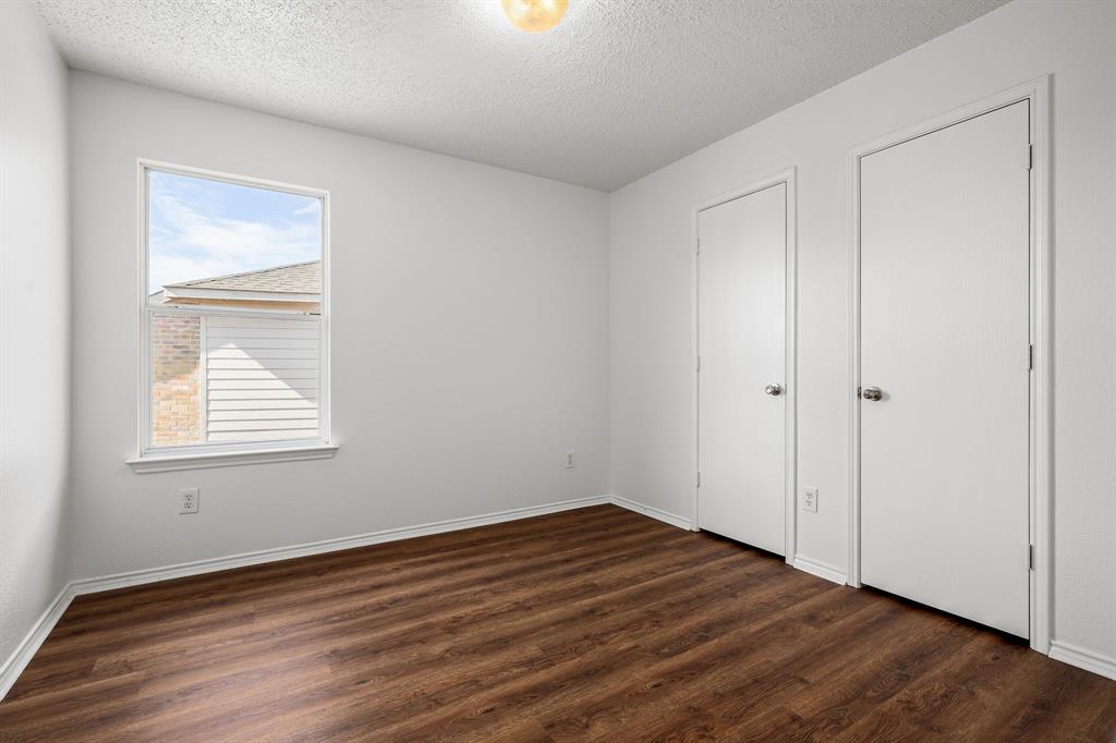 4816 Star Ridge Drive Fort Worth, TX 76133 - Photo 18 of 23 an empty room with wooden floor and windows