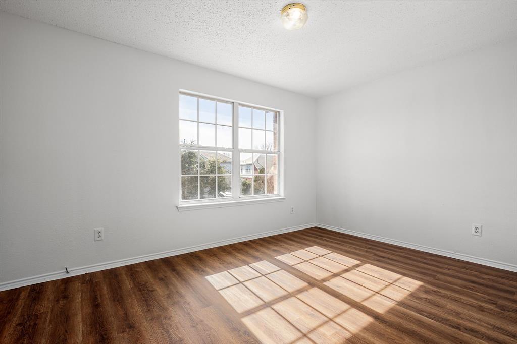 4816 Star Ridge Drive Fort Worth, TX 76133 - Photo 19 of 23 an empty room with wooden floor and windows