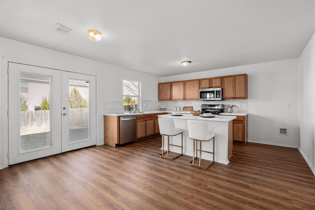 4816 Star Ridge Drive Fort Worth, TX 76133 - Photo 8 of 23 a kitchen with wooden floors and white cabinets