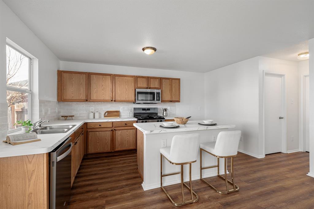 4816 Star Ridge Drive Fort Worth, TX 76133 - Photo 9 of 23 a kitchen with a sink a stove a refrigerator cabinets and dining table