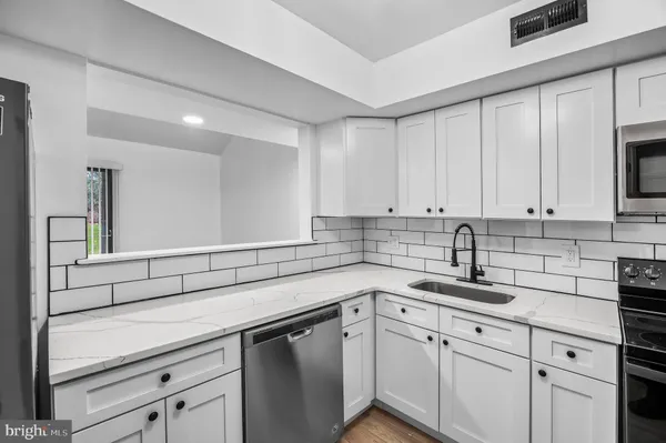 a kitchen with white cabinets and white appliances