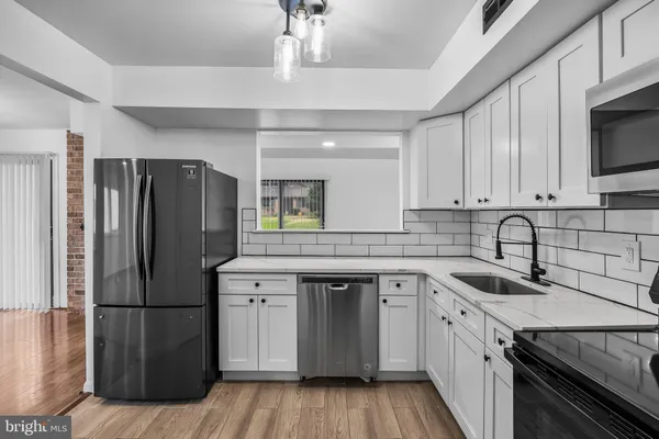 a kitchen with a sink stainless steel appliances and cabinets