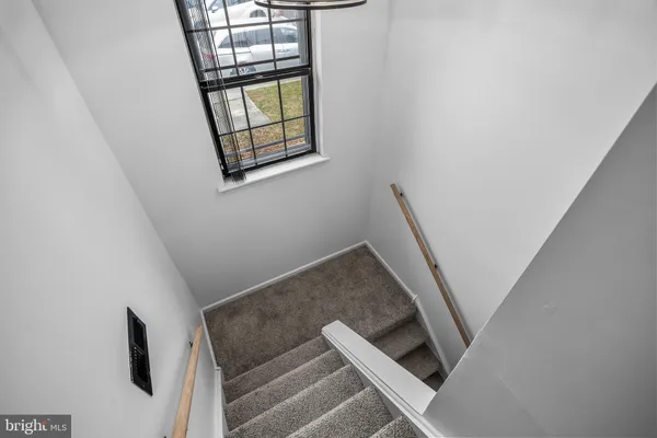 a view of staircase with white walls and window