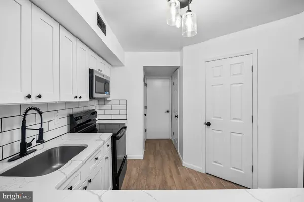 a kitchen with granite countertop a sink stove and cabinets