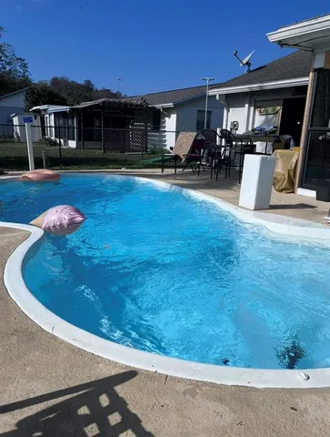 a view of a yard with table chairs and potted plants