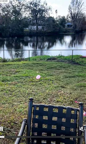 a view of a wooden deck and a yard with some potted plants