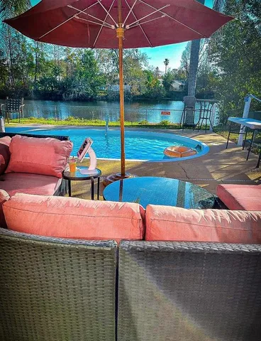 a view of a patio with a table and chairs under an umbrella