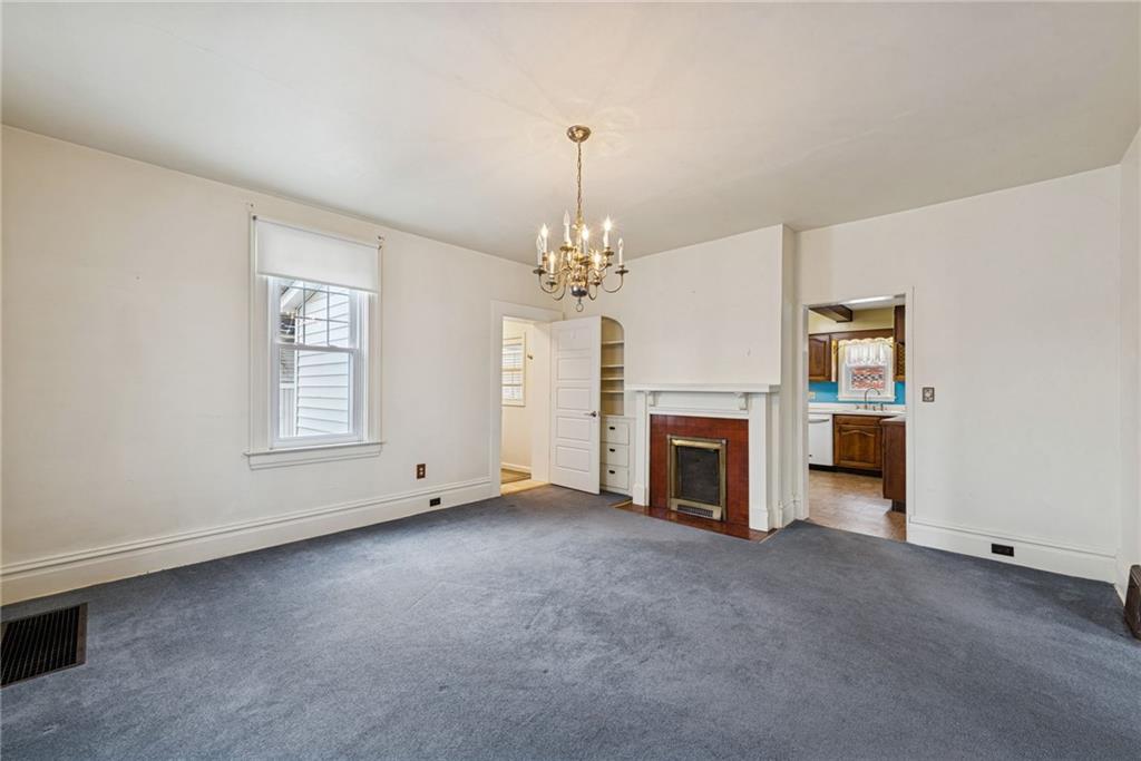 618 State Street Greensburg, PA 15601 - Photo 9 of 34 an empty room with fireplace chandelier and windows