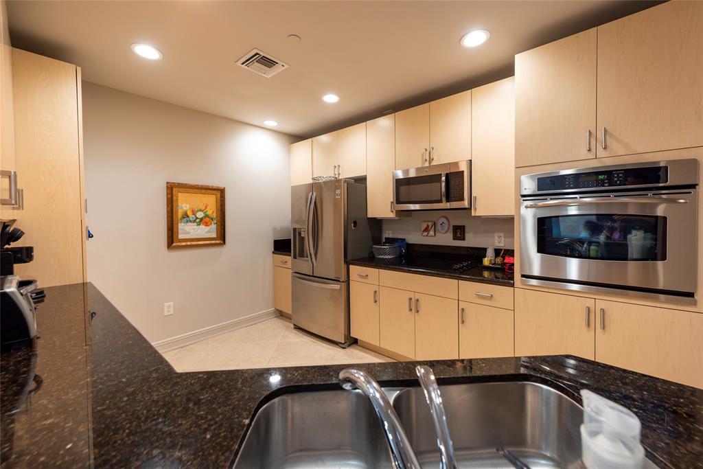 a kitchen with granite countertop a refrigerator and a stove top oven