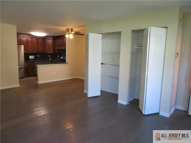 a view of kitchen with refrigerator and white cabinets