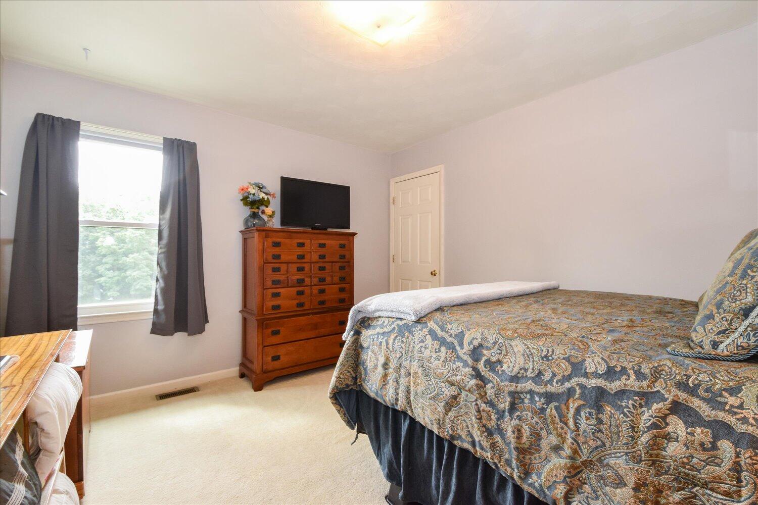 1535 Mountain View Road Vinton, VA 24179 - Photo 11 of 20 a bedroom with a bed and a flat tv screen on dresser