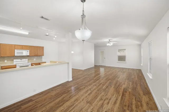 a view of a kitchen with a sink and wooden floor