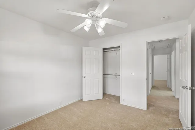 an empty room with fan and hallway