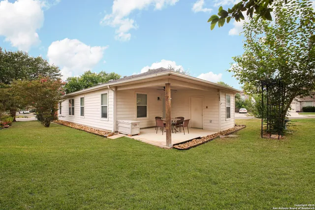 a view of a house with backyard and a tree