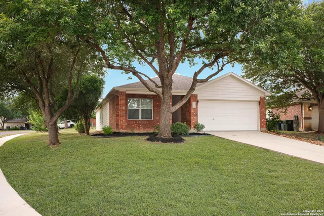 a front view of a house with a yard and trees