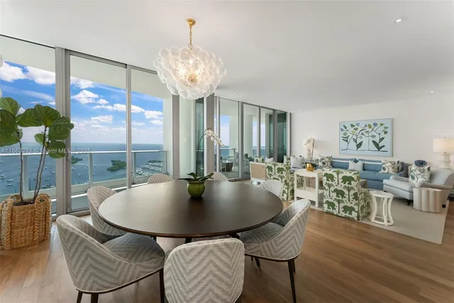 a dining room with furniture a chandelier and wooden floor
