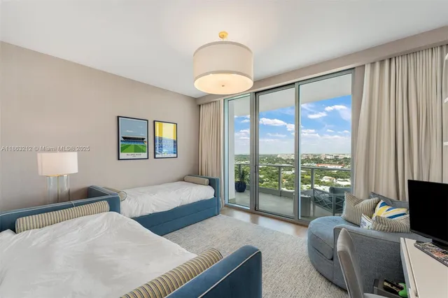 a bedroom with furniture and a large window