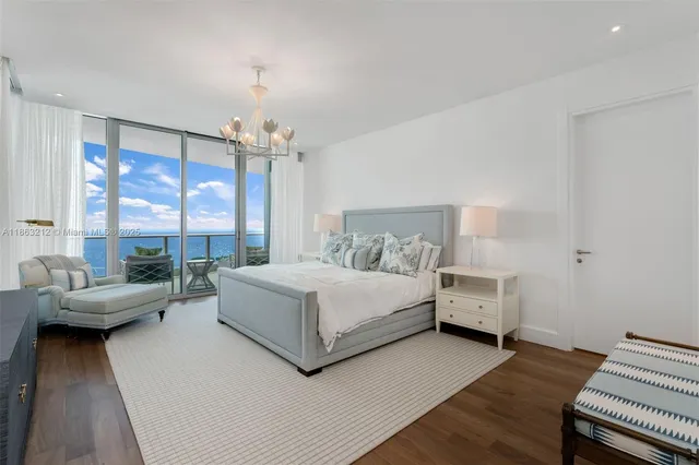 a bedroom with a bed and large windows