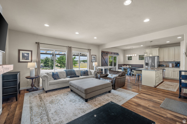 955 Delorean Lane Midvale, UT 84047 - Photo 7 of 47 Open-concept living space featuring wood-finish flooring, recessed lighting, and large windows