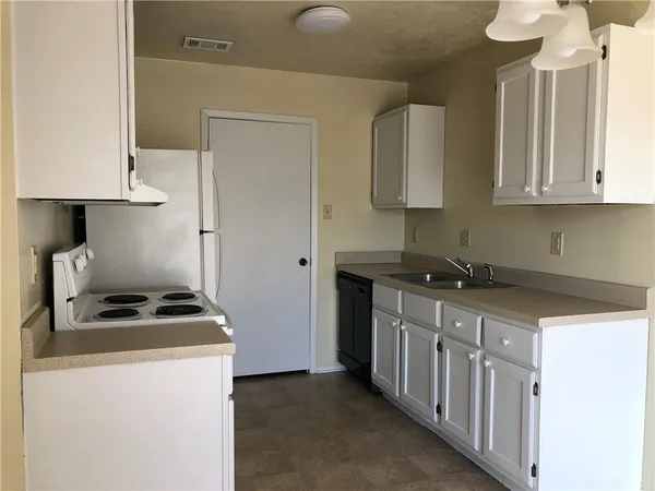 a kitchen with stainless steel appliances a stove a sink a refrigerator and cabinets
