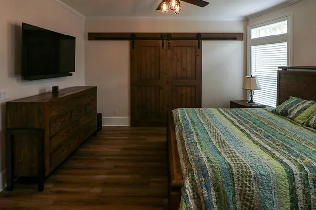 a bedroom with a bed and a flat tv screen on dresser