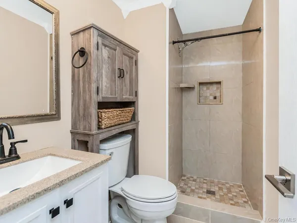 a bathroom with a granite countertop sink toilet and shower