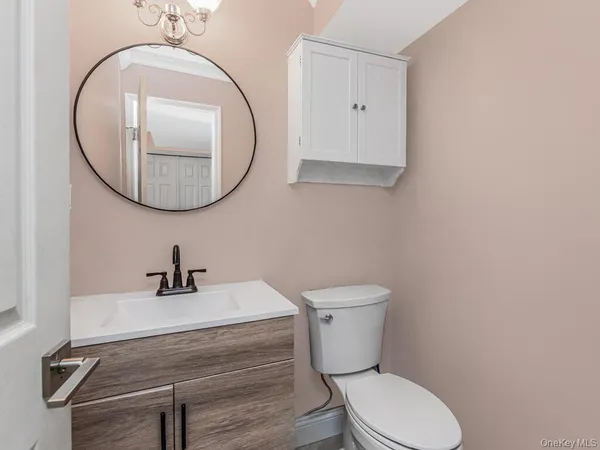 a bathroom with a toilet a sink and mirror