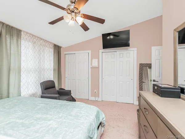 a bedroom with a bed a window and a flat screen tv