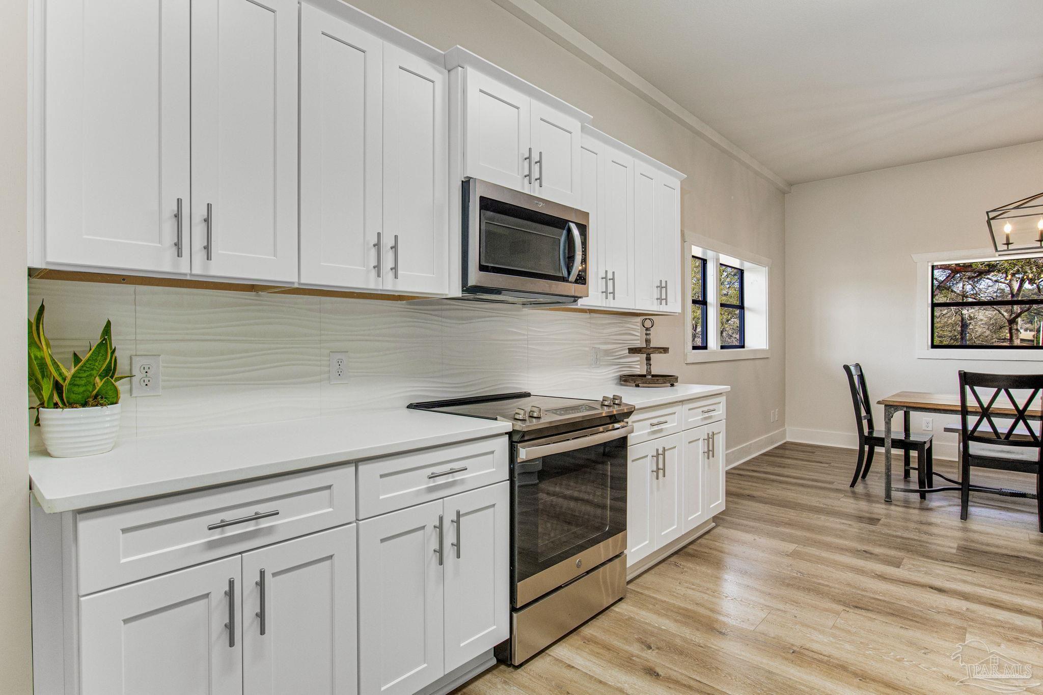 4664 Kolb Road Milton, FL 32570 - Photo 13 of 20 a kitchen with white cabinets and appliances