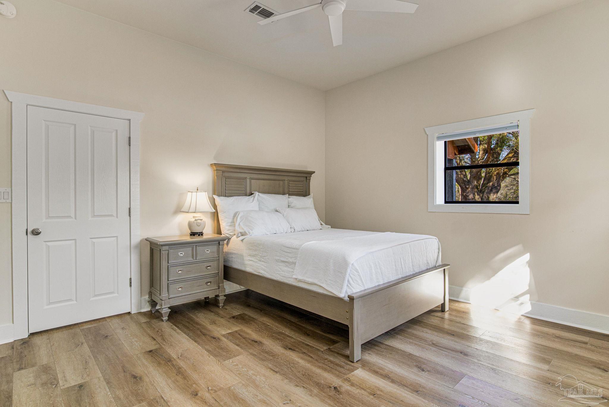 4664 Kolb Road Milton, FL 32570 - Photo 15 of 20 a bed room with a bed and a night stand