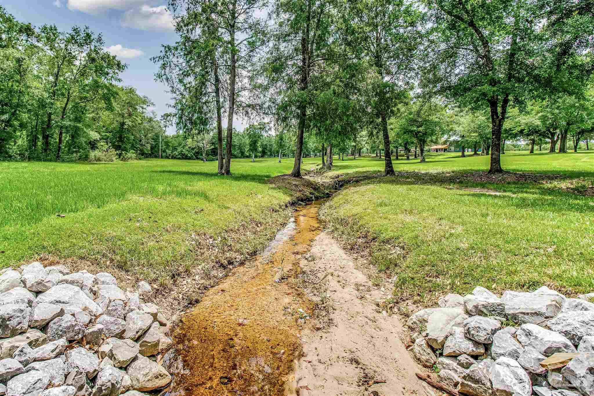 4664 Kolb Road Milton, FL 32570 - Photo 2 of 20 a view of grassy field with benches