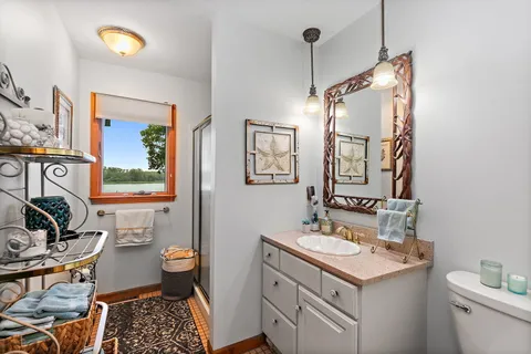 a spacious bedroom with a bed dresser and a flat tv screen