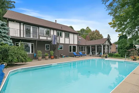 a view of a lake with couches chairs and wooden floor