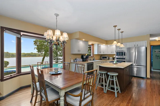 a open kitchen with stainless steel appliances granite countertop a stove a sink dishwasher and a fireplace with wooden floor