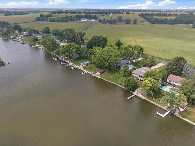 an aerial view of a house with a garden and lake view