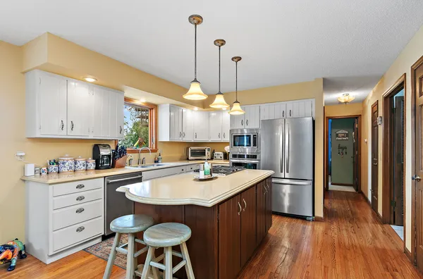 a kitchen with a island a sink stainless steel appliances and cabinets