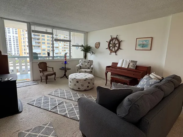 a living room with furniture large window and a flat screen tv