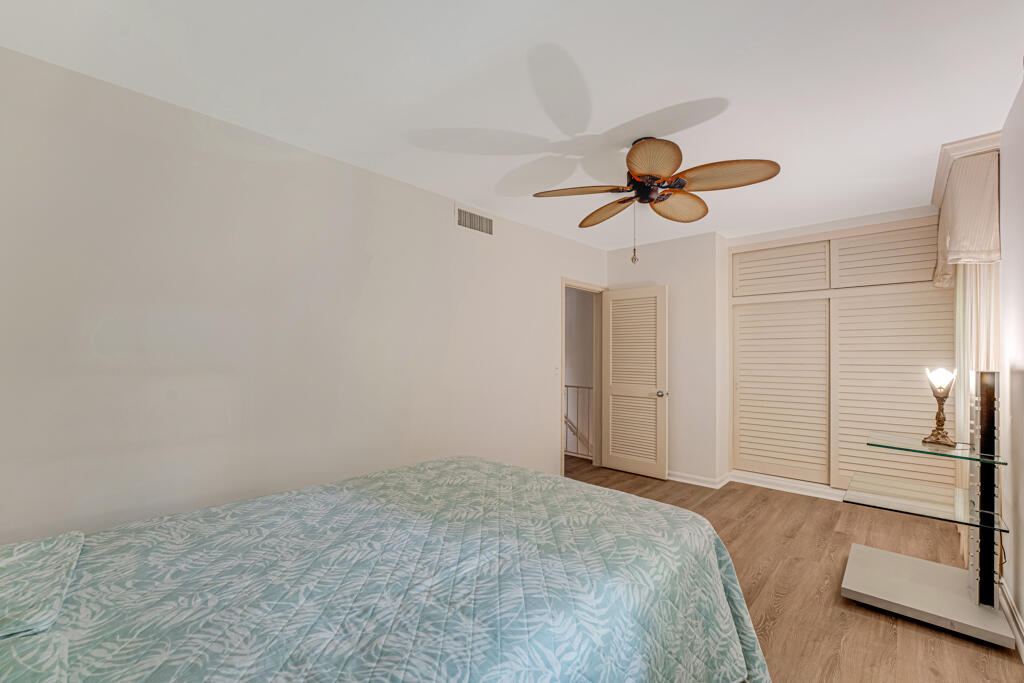 6590 North Ocean Boulevard, Unit 3 Ocean Ridge, FL 33435 - Photo 27 of 48 a bedroom with a bed and a chandelier fan