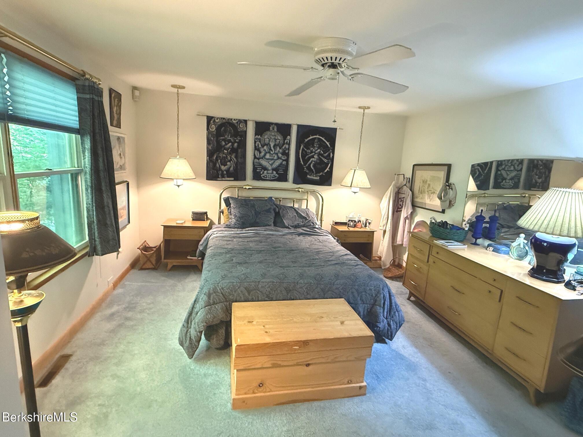 58 Evergreen Road Otis, MA 01029 - Photo 14 of 27 a spacious bedroom with a bed a mirror and window