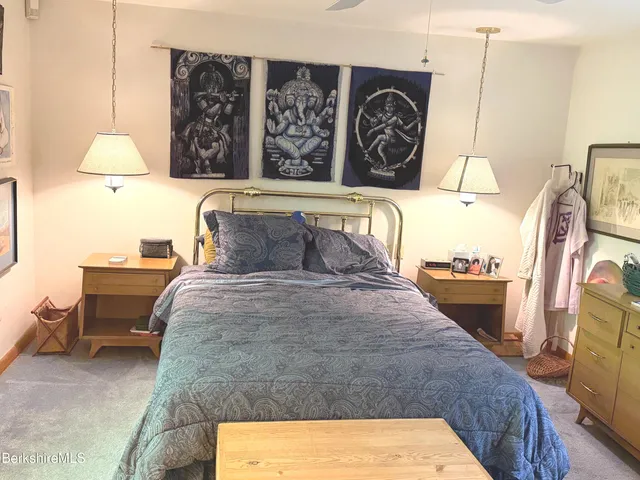 a bedroom with a bed and dresser with mirror