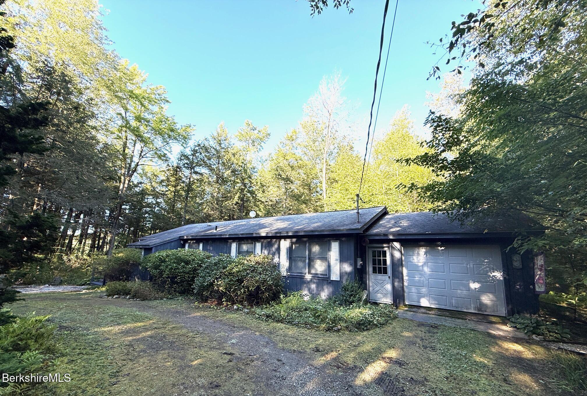58 Evergreen Road Otis, MA 01029 - Photo 3 of 27 a view of a house that has a small yard and large trees