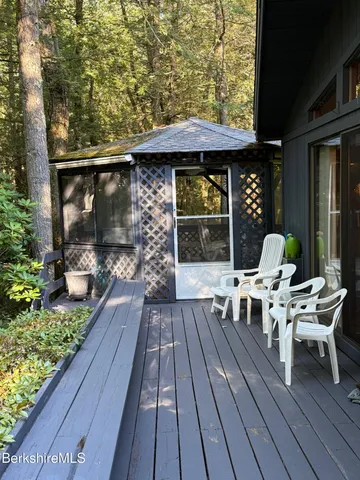 a balcony with wooden floor table and chairs
